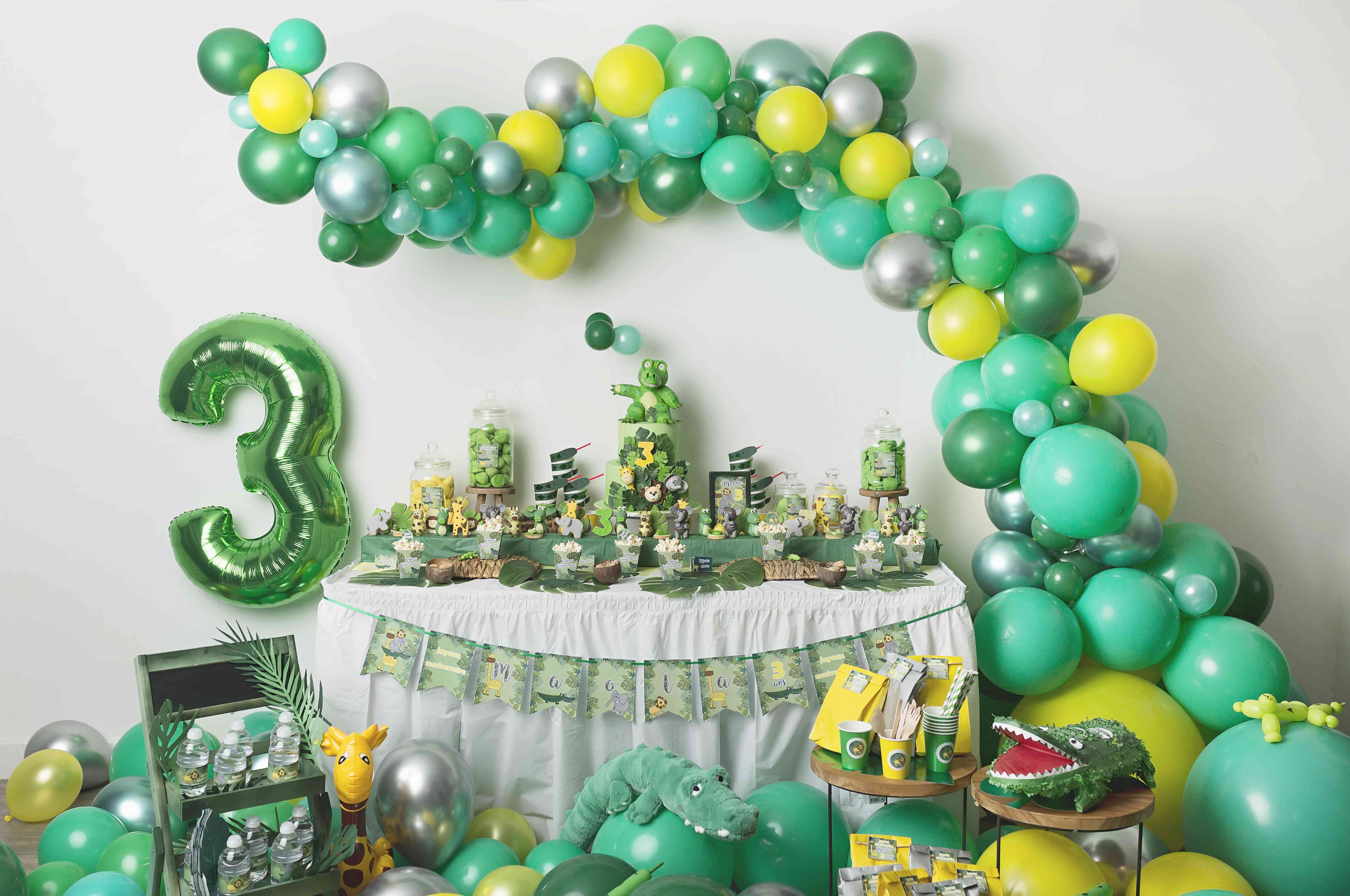 Une Fête D'anniversaire Verte Et Dorée Avec Un Ballon Vert Et Un Gâteau Sur  La Table.